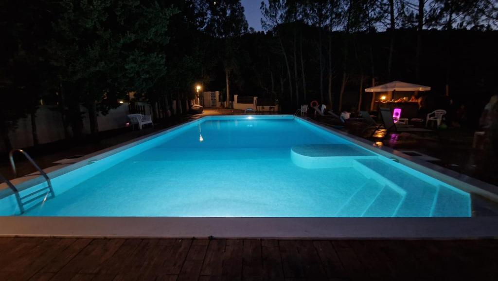 - une grande piscine bleue la nuit dans l'établissement VILLA STRAVANATA - Large Pool, Car and Large Whirlpool Jacuzzi, à San Gregorio