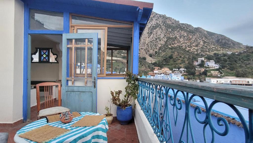 d'un balcon avec une table et une vue sur la montagne. dans l'établissement Honey Suckle, à Chefchaouen