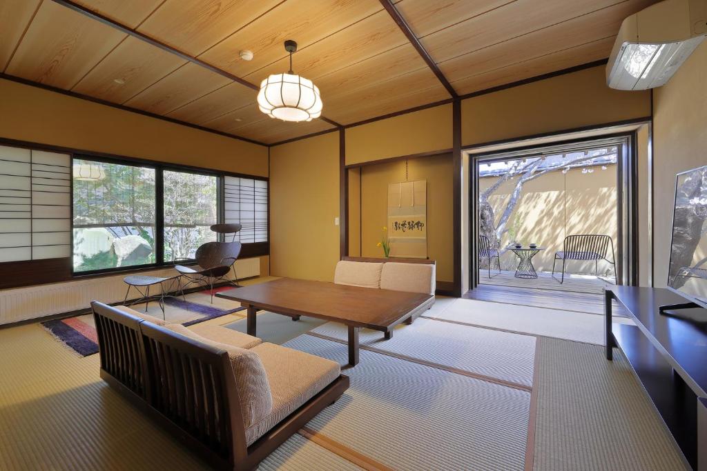 un salon avec une table et des chaises et une fenêtre dans l'établissement 天童荘 TENDOSO, à Tendō