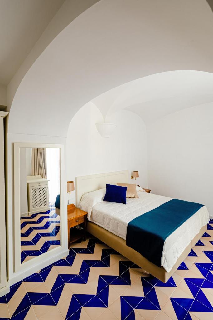 - une chambre avec un lit et un sol bleu et blanc dans l'établissement Hotel Da Raffaele, à Ischia 50 autres photos