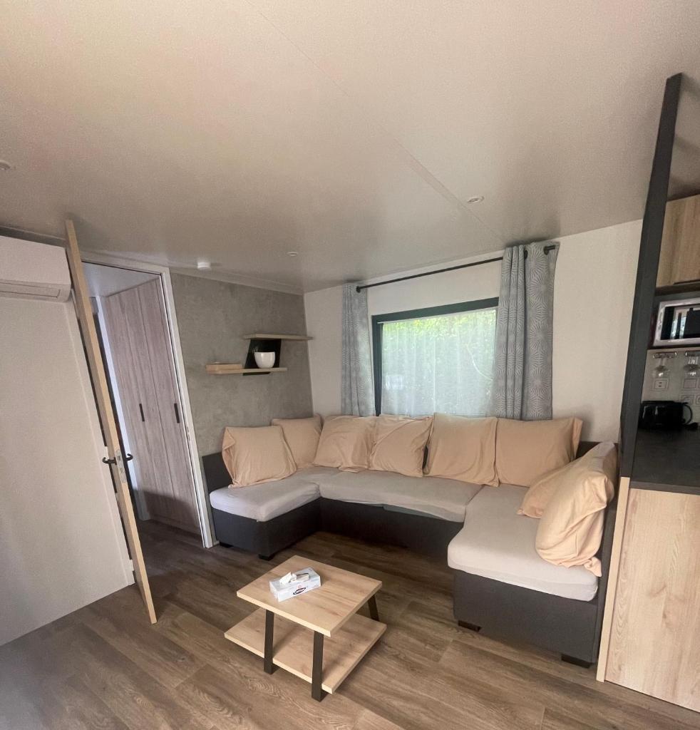 un salon avec un canapé et une table dans l'établissement Mobil-Home Eucalyptus 1, à Valras-Plage