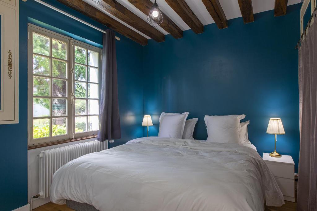 - une chambre bleue avec un grand lit et des oreillers blancs dans l'établissement Le Domaine de Baracas - Le Grand Gîte 4 étoiles - piscine-billard-baby-foot-cheminée - 14 personnes, à Huisseau-sur-Mauves 30 autres photos