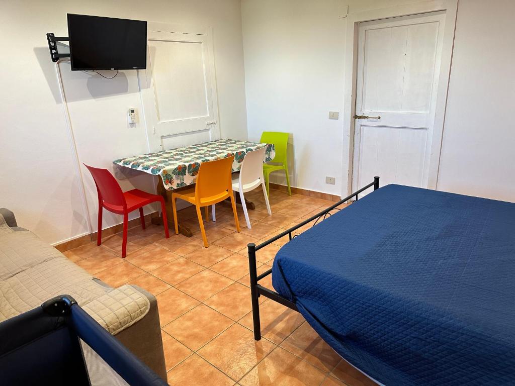 une chambre avec une table, des chaises et un lit dans l'établissement House Cefalù 1915, à Lascari