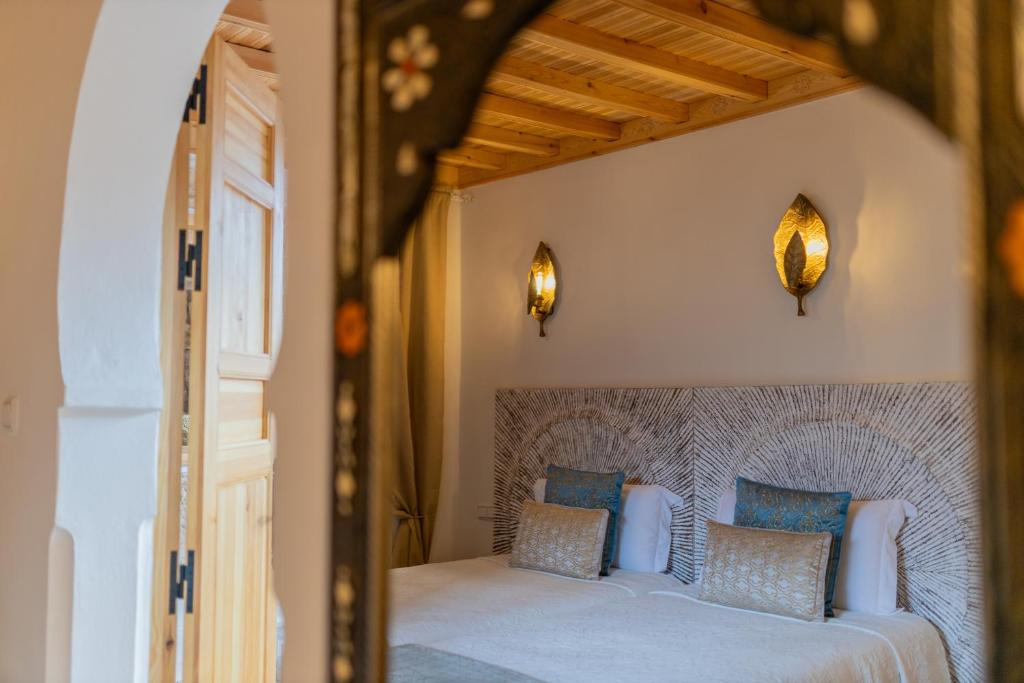 une chambre avec un grand lit avec des oreillers bleus dans l'établissement Riad Nila, à Chefchaouen