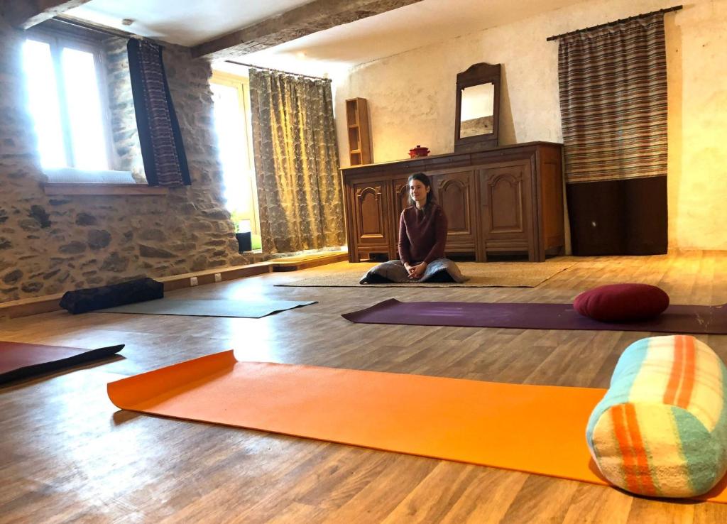 une femme assise au sol dans une pièce avec tapis de yoga dans l'établissement Fenêtre sur les Pyrénées, à Soulan 15 autres photos