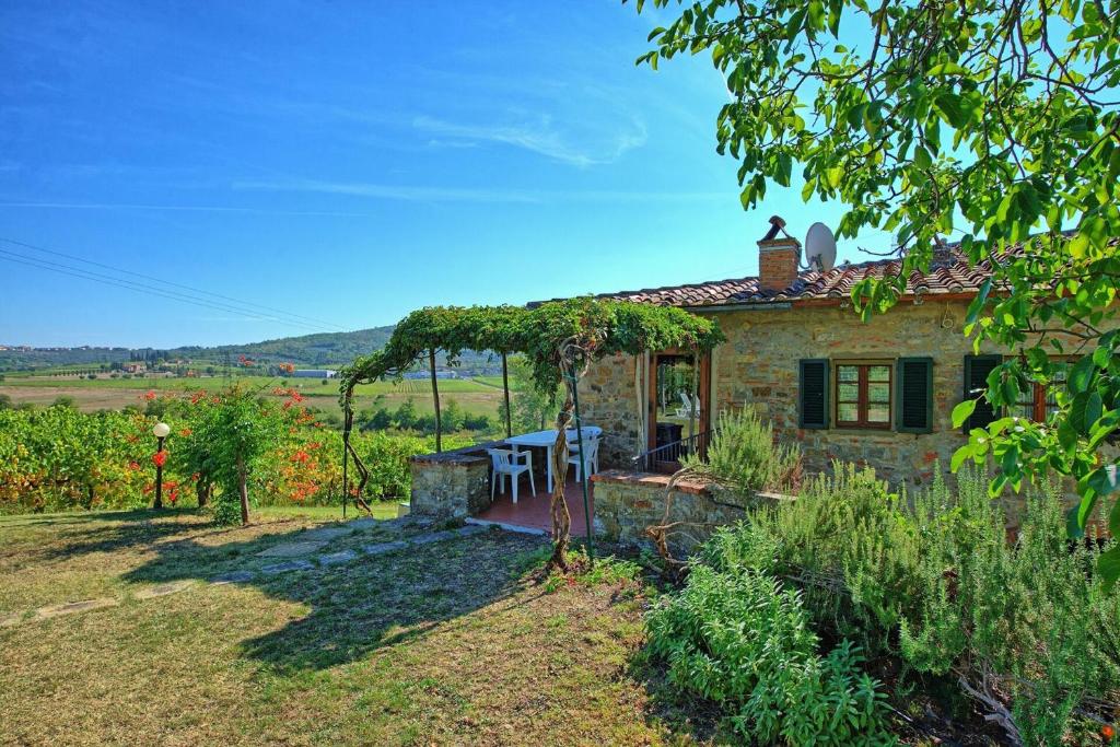 une maison en pierre avec une table et des chaises dans une cour dans l'établissement Villa Scerfia by Mmega, à Badia Agnano