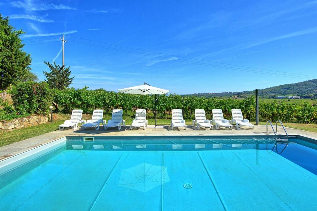 une piscine avec des chaises longues et un parasol dans l'établissement Villa Scerfia by Mmega, à Badia Agnano