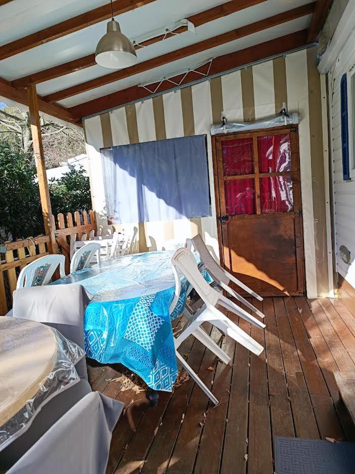 une terrasse couverte avec une table et des chaises. dans l'établissement Les Grands Pins emplacement numéro 103, au Castellet