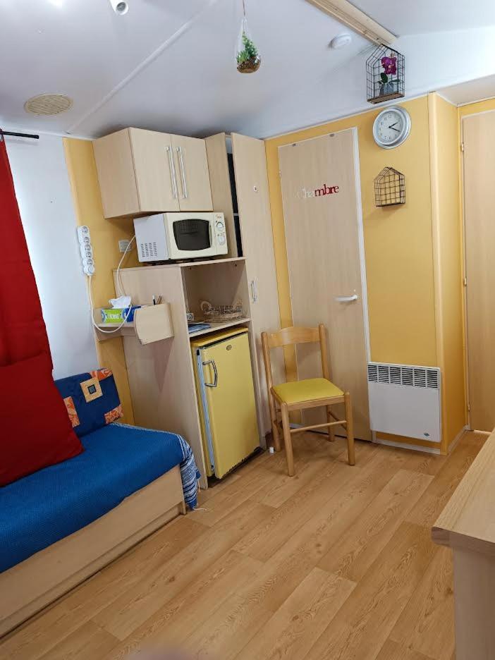 Cette petite chambre dispose d'une cuisine avec un lit et un four micro-ondes. dans l'établissement Les Grands Pins emplacement numéro 103, au Castellet