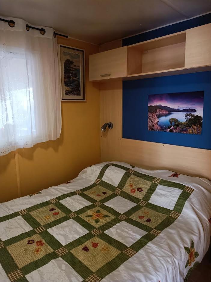 un lit avec une couette dessus dans une chambre dans l'établissement Les Grands Pins emplacement numéro 103, au Castellet 11 autres photos