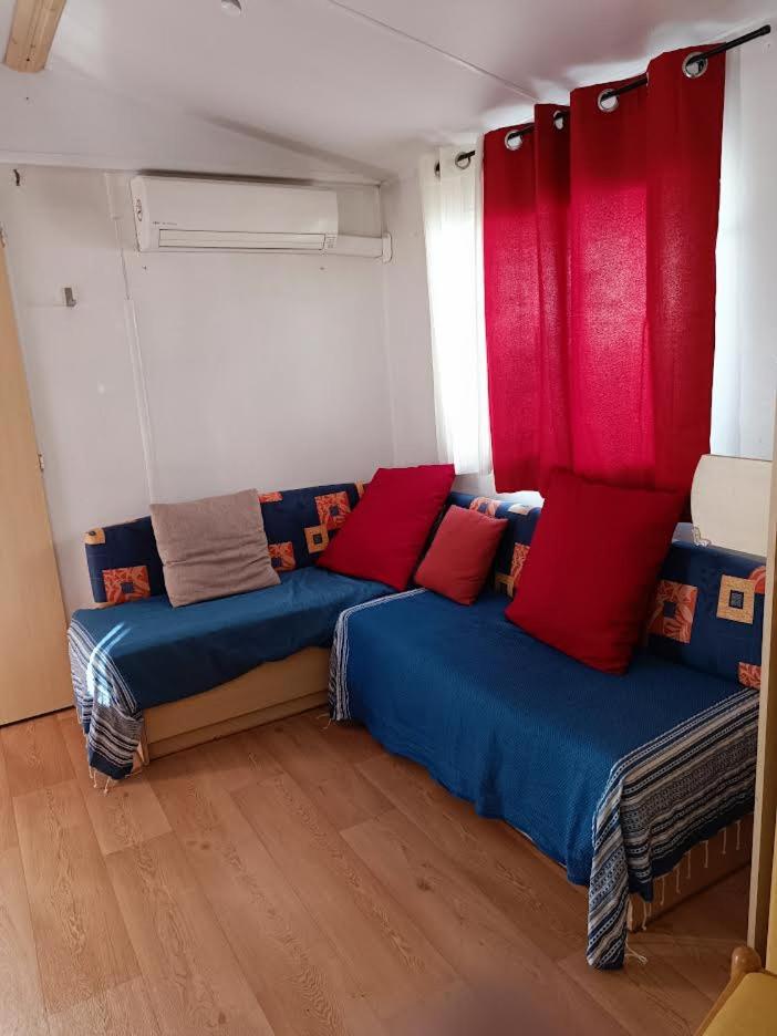 - 2 lits dans une chambre avec des oreillers rouges et bleus dans l'établissement Les Grands Pins emplacement numéro 103, au Castellet