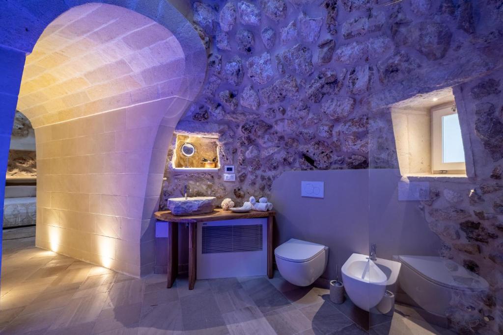 une salle de bains pourpre avec toilettes et lavabo. dans l'établissement Lisària Villa Delle Meraviglie With Pool, à Castrignano deʼ Greci