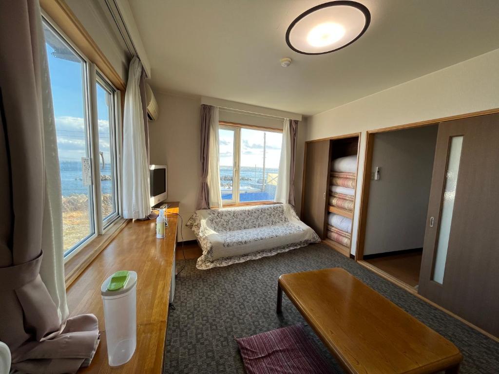 un salon avec un lit et une grande fenêtre dans l'établissement LiVEMAX RESORT Shiretoko Sea Front, à Rausu