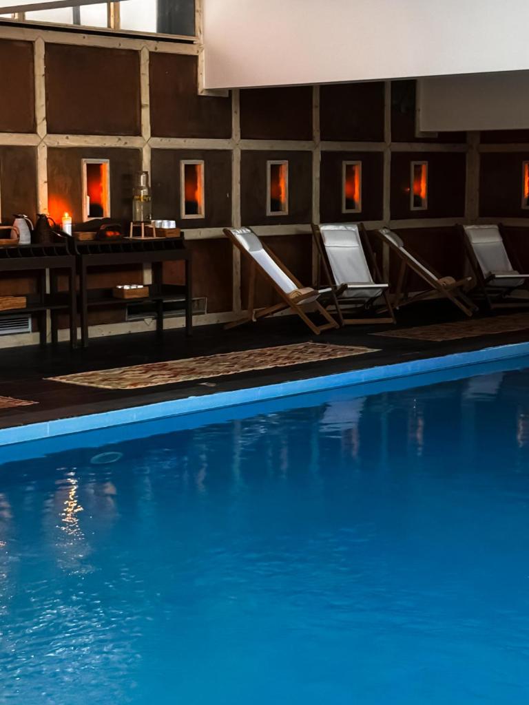 une piscine avec des chaises et une table dans l'établissement Alpes Hôtel du Pralong, à Courchevel