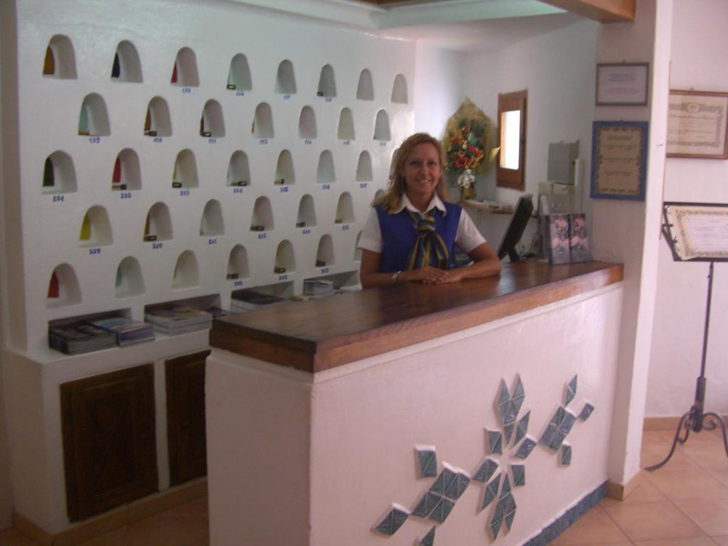 une femme debout à un comptoir dans un magasin dans l'établissement Hotel Capriccioli, à Porto Cervo 69 autres photos