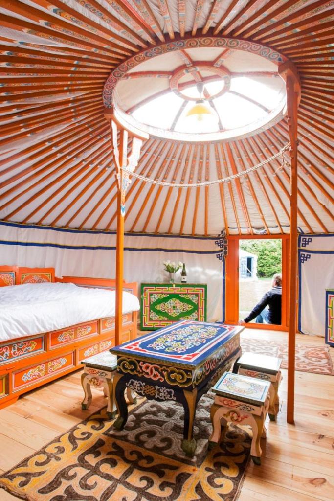 une chambre avec un lit et une table dans une tente dans l'établissement Rando-Yourte, à Paluel