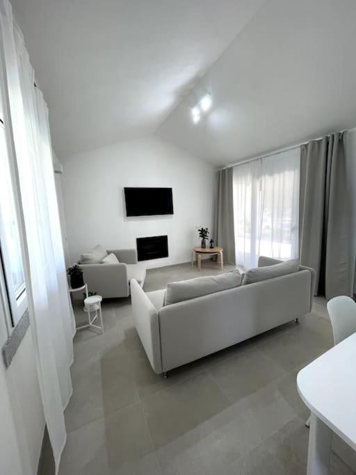 un salon blanc avec un canapé et une télévision dans l'établissement Villa Ami, à Castiadas 39 autres photos