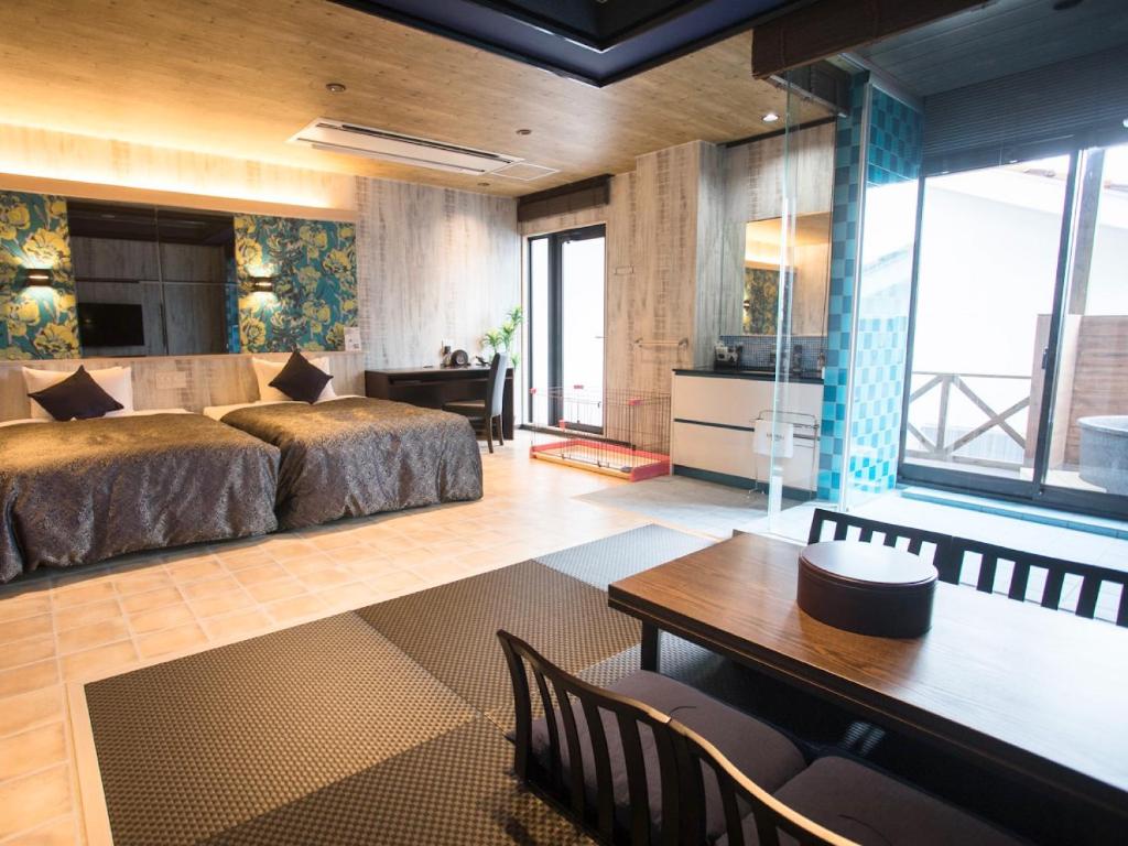 une chambre avec un lit, une table et des chaises dans l'établissement LiVEMAX RESORT Kyotango Sea Front, à Kyōtango