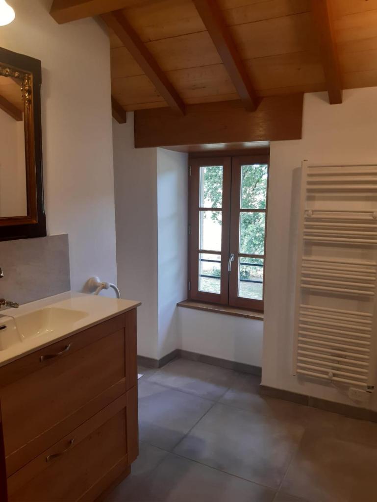 une salle de bain avec un lavabo et une fenêtre dans l'établissement Gîte Amélie, à Lanuéjouls-et-Privezac