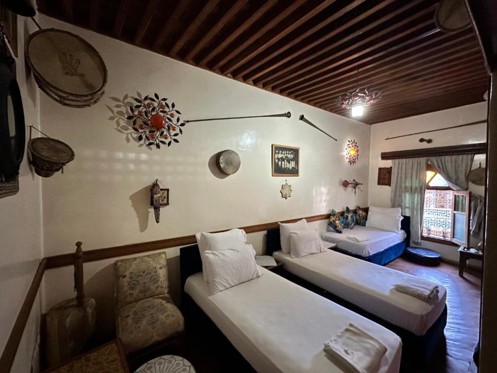 Cette chambre comprend trois lits et un canapé. dans l'établissement Museum House - Dar Melyani, à Fès 37 autres photos