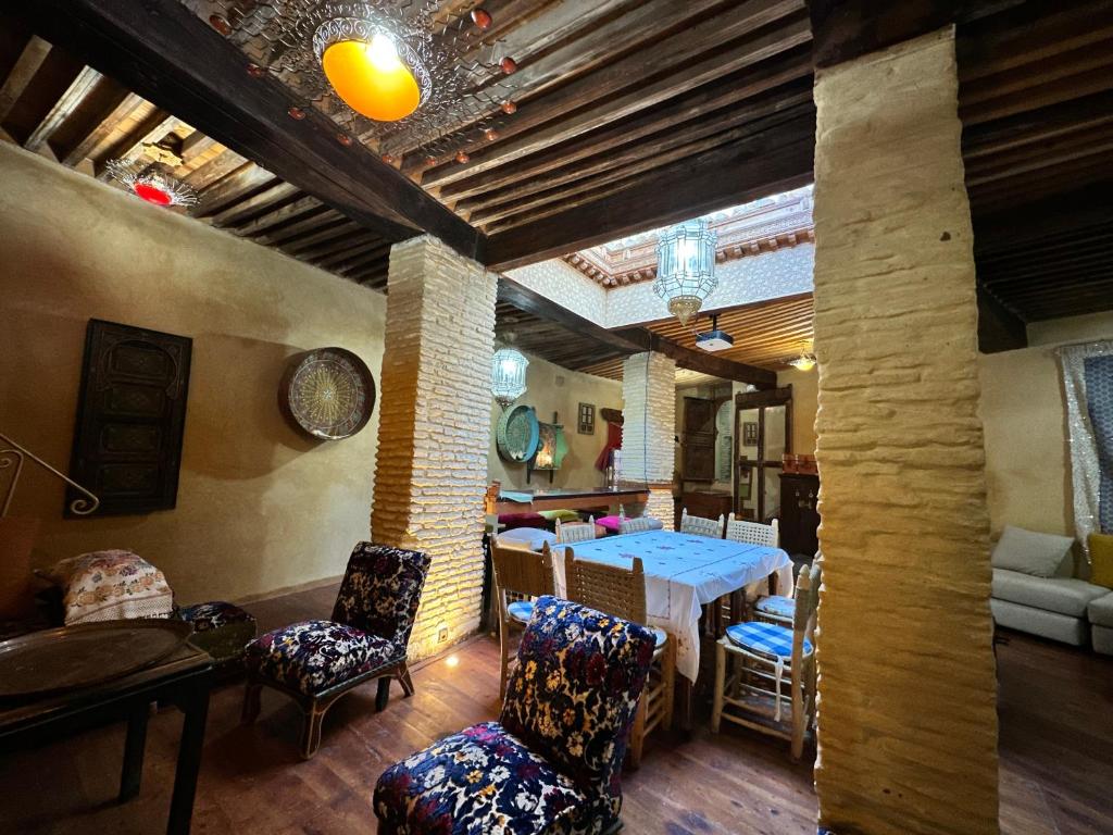 une salle à manger avec une table et des chaises dans une pièce dans l'établissement Museum House - Dar Melyani, à Fès