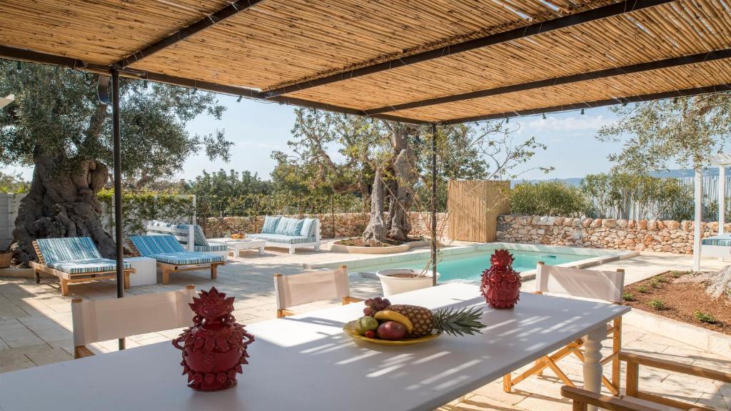 - une terrasse avec une table et un bol de fruits dans l'établissement Masseria Torre Coccaro, à Savelletri di Fasano