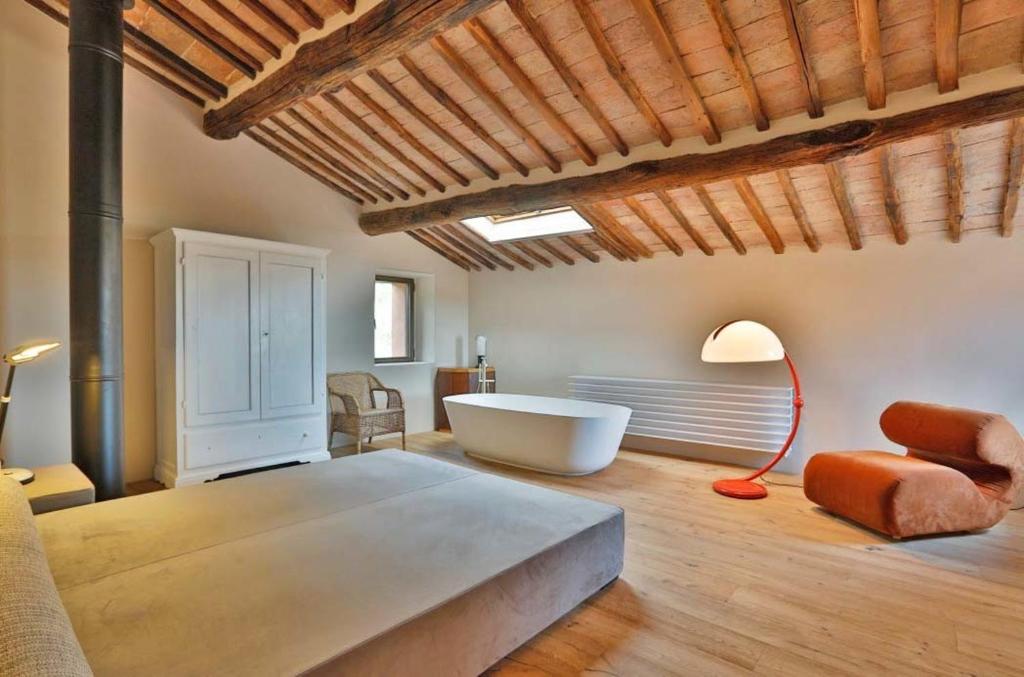 une chambre avec un grand lit et une baignoire dans l'établissement Casagatti villa di lusso, à Fungaia