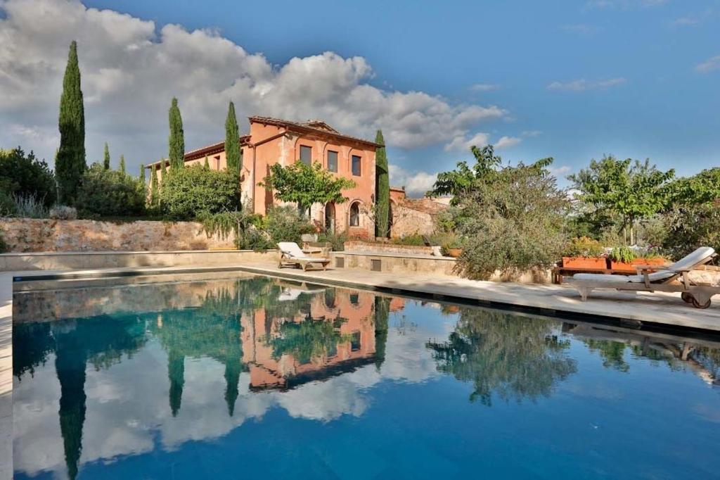 une piscine d'eau en face d'une maison dans l'établissement Casagatti villa di lusso, à Fungaia