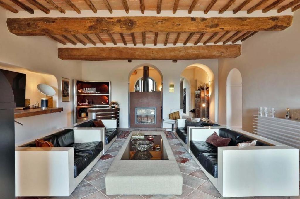 un salon avec deux canapés et une cheminée dans l'établissement Casagatti villa di lusso, à Fungaia
