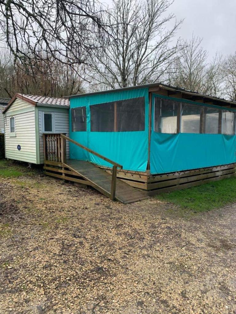 un mobile home avec une couverture bleue sur une terrasse dans l'établissement Mobilhome, à Castillonnès
