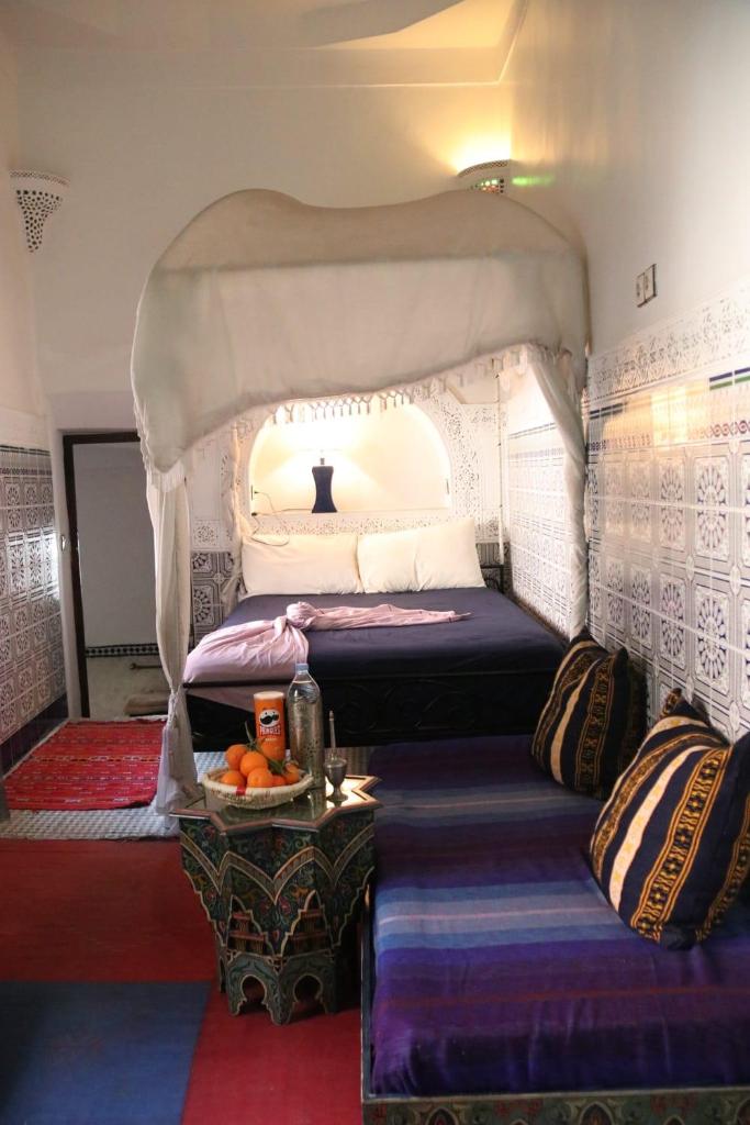 une chambre avec un lit à baldaquin dans l'établissement RIAD Redous, à Marrakech 37 autres photos
