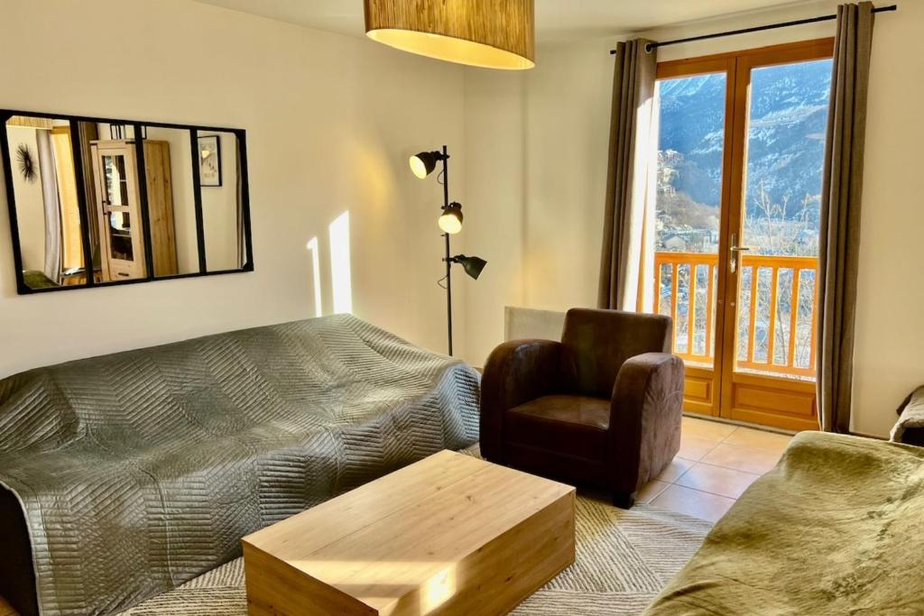 un salon avec un canapé et une chaise dans l'établissement Joli triplex avec jardin et vue, à Puy-Saint-Pierre