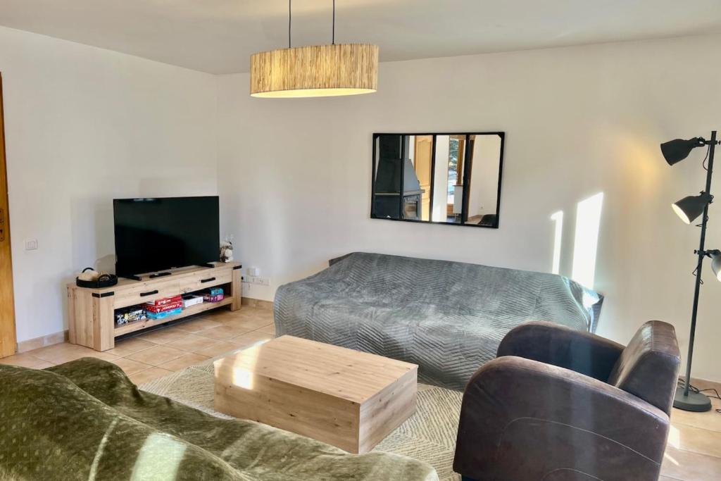 un salon avec un canapé et une télévision dans l'établissement Joli triplex avec jardin et vue, à Puy-Saint-Pierre