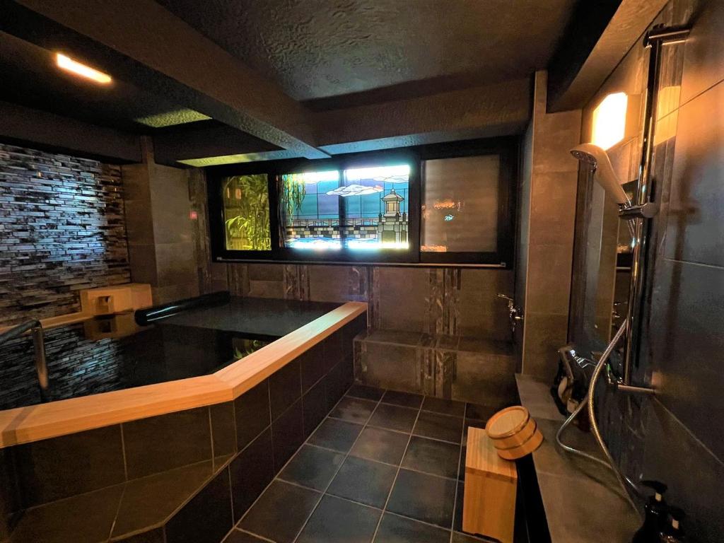 une salle de bain avec une baignoire et une fenêtre dans l'établissement Koyado Enn, à Toyooka