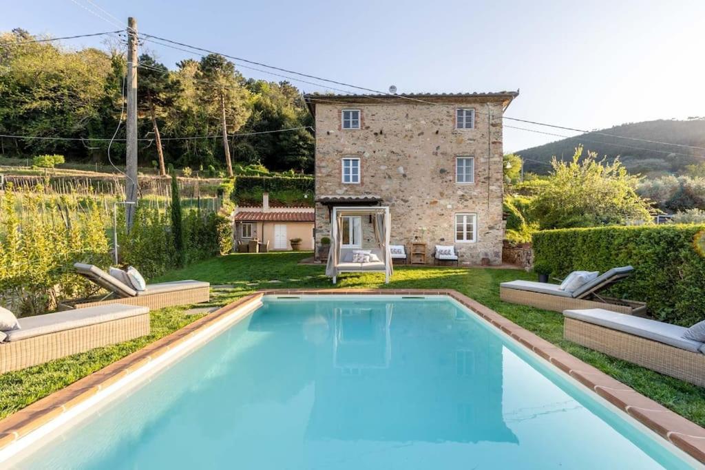 une grande piscine devant une maison dans l'établissement Villa Aperitivo, Romantic and Panoramic Stone Farm, à Capannori