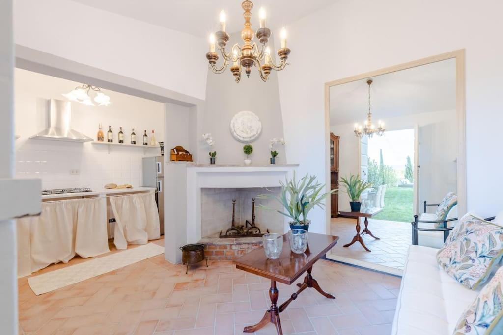 d'un salon avec une cheminée et un lustre. dans l'établissement Villa Aperitivo, Romantic and Panoramic Stone Farm, à Capannori