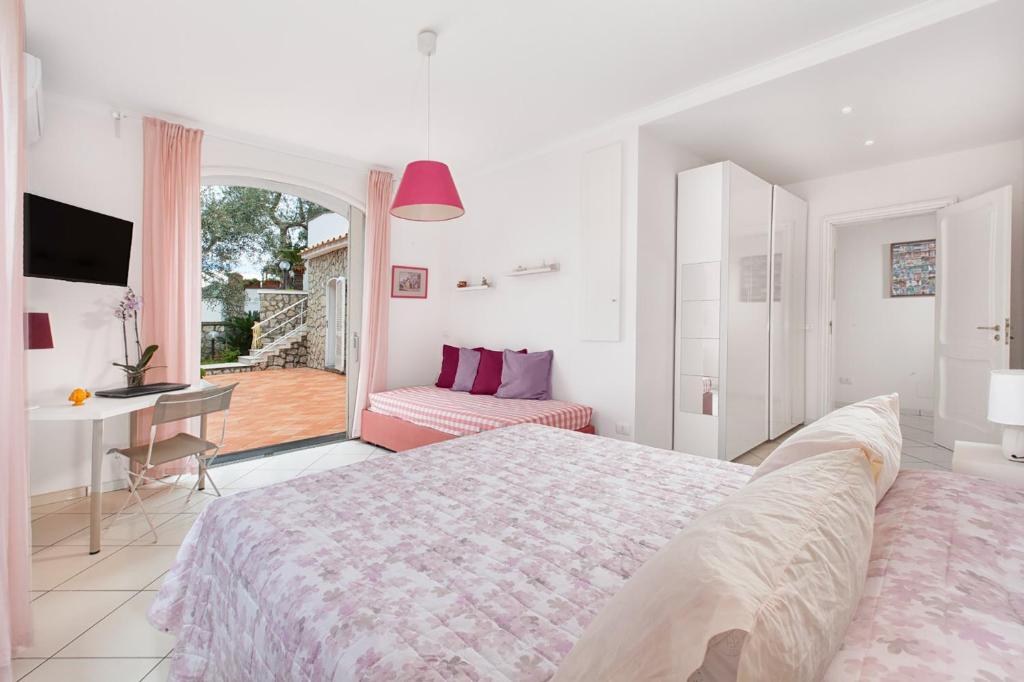 une chambre avec un lit et un bureau et un balcon dans l'établissement YourHome - Villa Triludonia, à Massa Lubrense