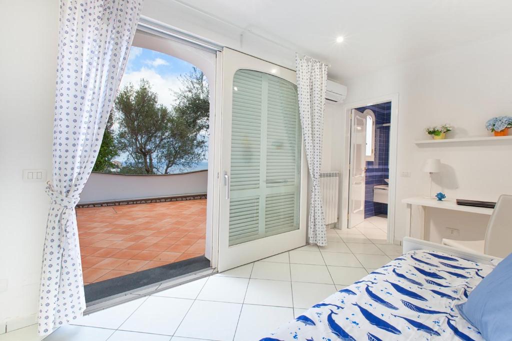 une chambre avec une porte ouverte sur un balcon dans l'établissement YourHome - Villa Triludonia, à Massa Lubrense