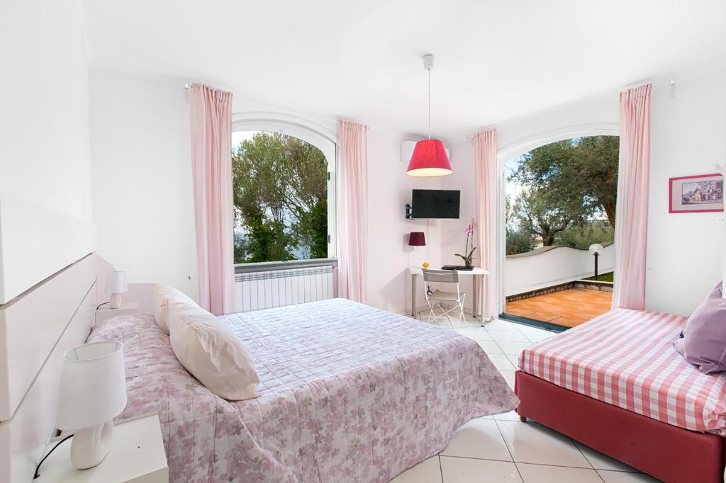 une chambre blanche avec un lit et deux fenêtres dans l'établissement YourHome - Villa Triludonia, à Massa Lubrense 58 autres photos