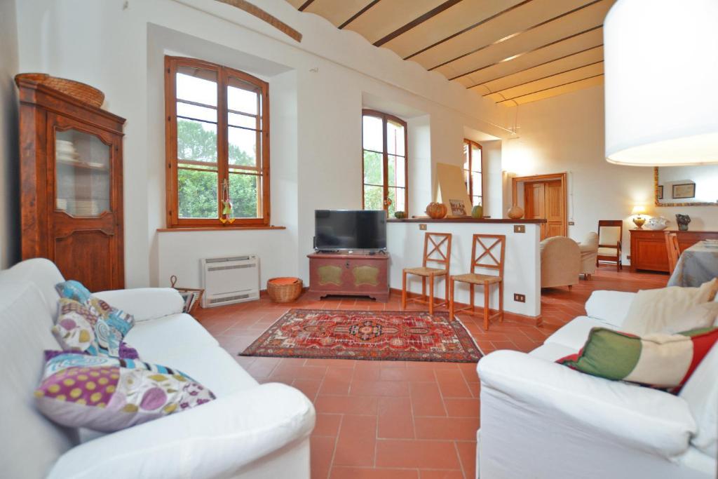 - un salon avec des canapés blancs et une cheminée dans l'établissement Villa Piandisette, à Cetona