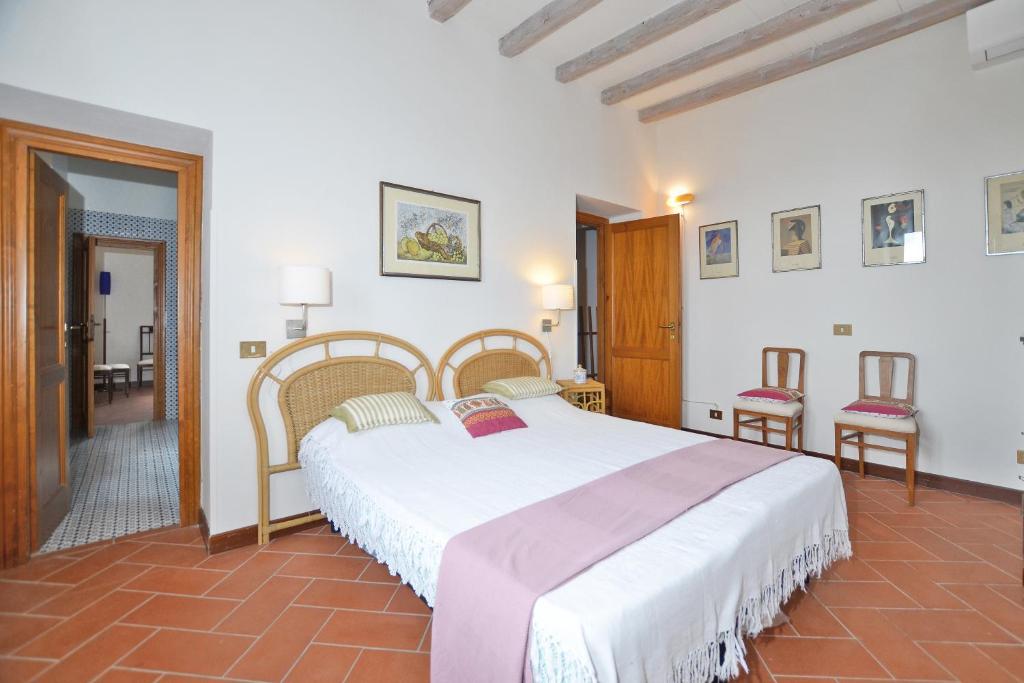 une chambre avec un grand lit et deux chaises dans l'établissement Villa Piandisette, à Cetona 40 autres photos