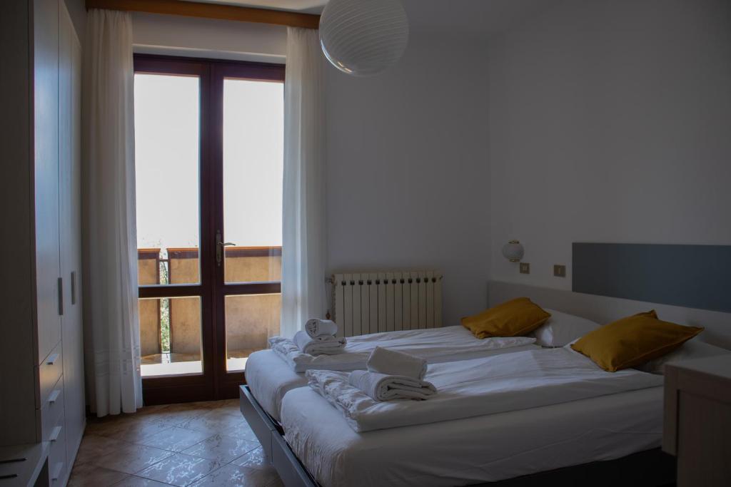 un grand lit dans une chambre avec une grande fenêtre dans l'établissement Residence Miravalle, à Limone sul Garda