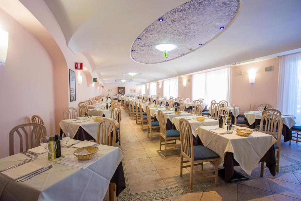 une salle à manger avec des tables et des chaises avec des nappes blanches dans l'établissement Hotel Terme Cristallo Palace & Beach, à Ischia