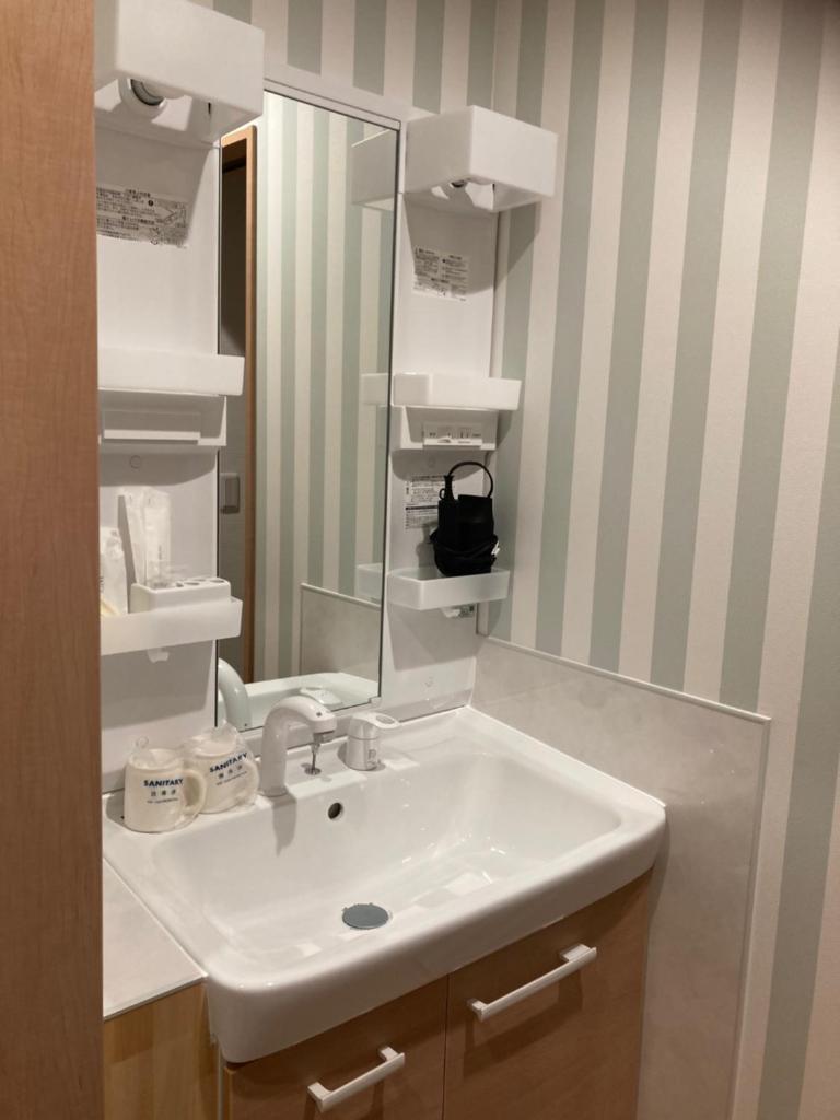 une salle de bain avec un lavabo et un miroir dans l'établissement Ryokan Fujitomita, à Oshino