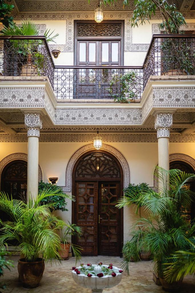 un bâtiment avec un balcon agrémenté de plantes dans une cour dans l'établissement La Villa des Orangers - Relais & Châteaux, à Marrakech