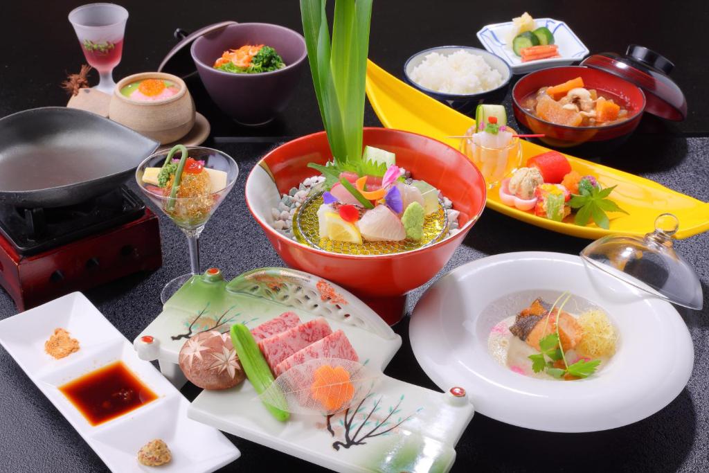 une table avec des assiettes de nourriture sur une table dans l'établissement Shikanoyu Hotel, à Komono