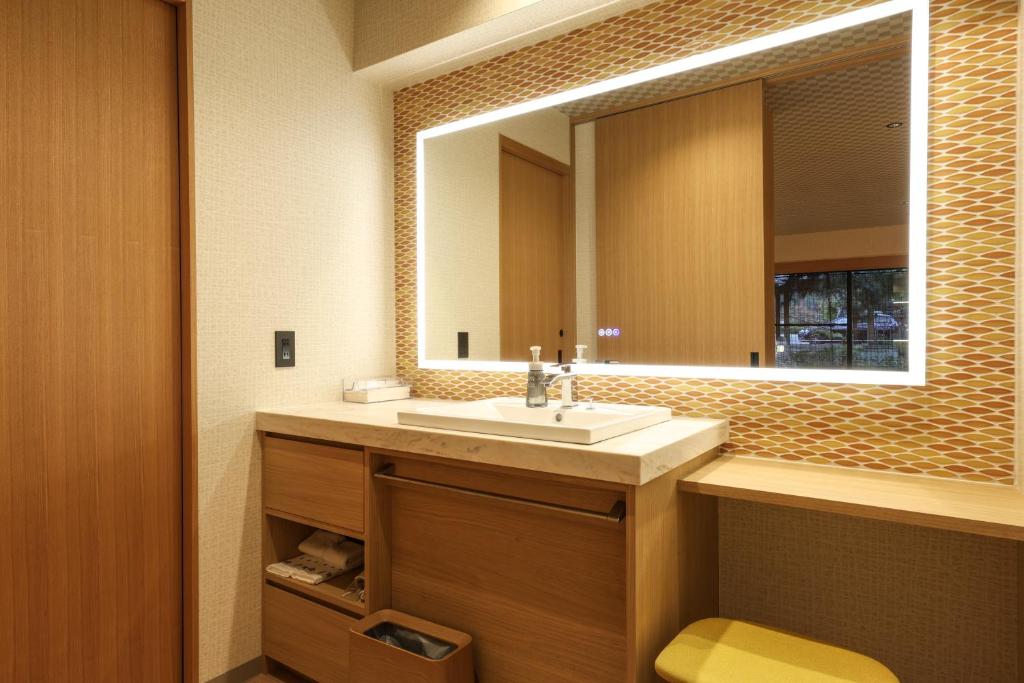 une salle de bain avec un lavabo et un miroir dans l'établissement SPA TERRACE Shisui, à Kobe