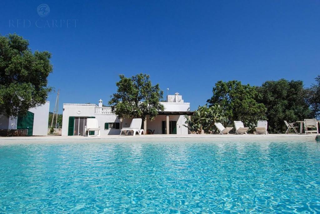 une villa avec piscine devant une maison dans l'établissement Masseria Terramare, à Macchia di Monte