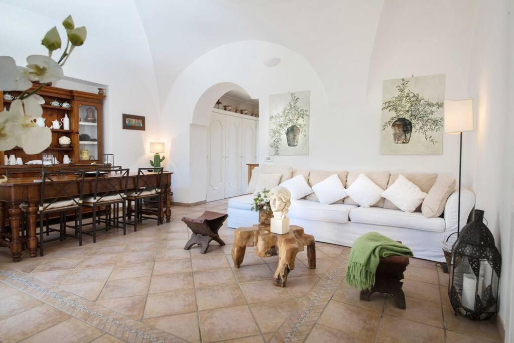 - un salon avec un canapé blanc et un piano dans l'établissement Luxury Villa Zaffiro - Pool, Garden and Sea View, à Anacapri