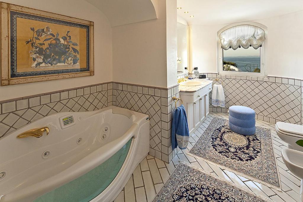 une salle de bains avec baignoire et lavabo dans l'établissement Excelsior Belvedere Hotel & Spa, à Ischia